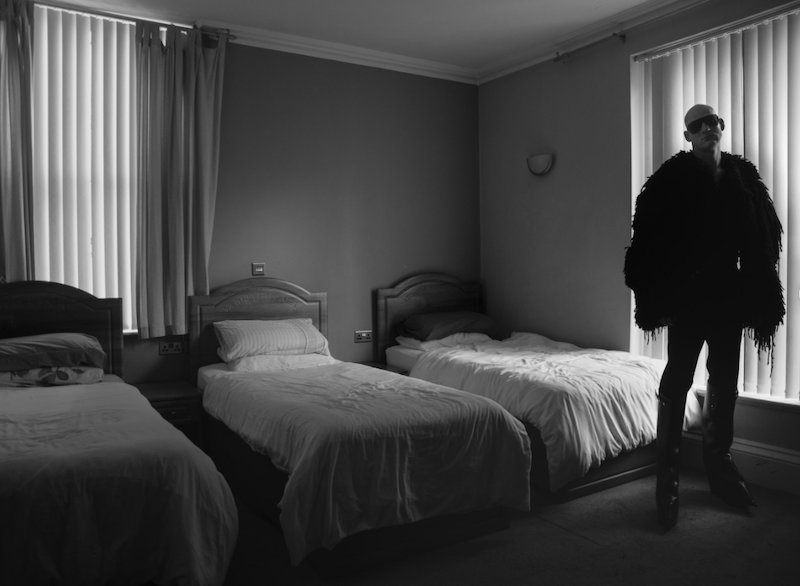 Blackhaine in a Dimly lit hotel room