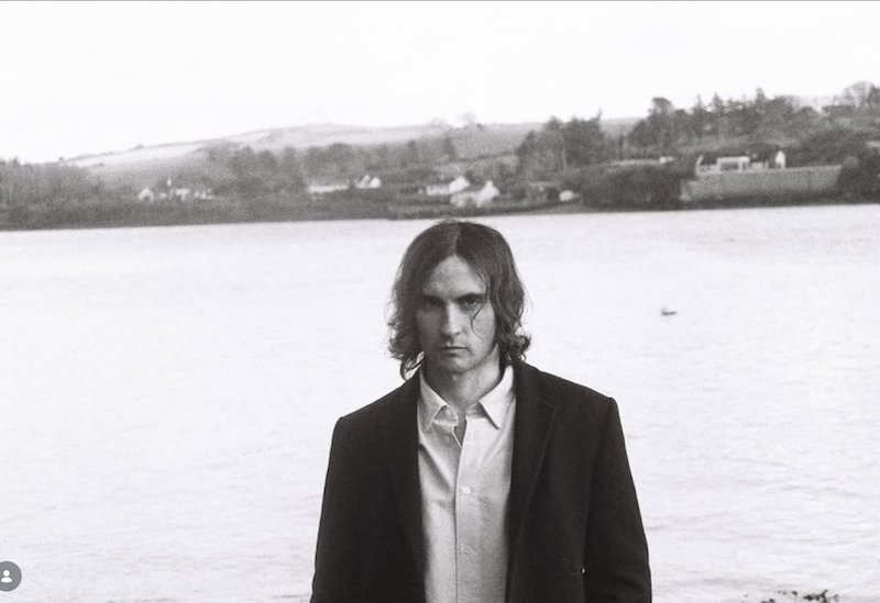 Oisinmod standing in front of a river