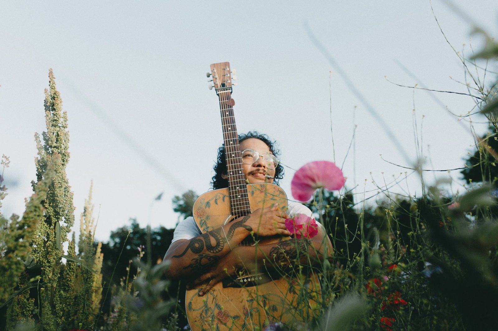 Janky Bungag Hugging Guitar in a Field of Wildflowers